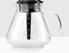 A clear studio shot of a glass coffee pot with a black lid and filter holder. Produktbild-Vorschau