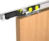 A close-up view of a sliding door hardware system attached to a wooden door. Produktbild-Vorschau