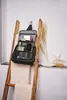 A black toiletry bag hangs from a hook on a wooden ladder, filled with various toiletries. Two towels are draped over the ladder. Produktbild-Vorschau