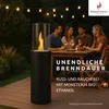 People gathered around a table on a deck at night, with string lights overhead and a modern ethanol fireplace. Produktbild-Vorschau