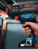 A hand holding a Bosch cordless impact wrench, working on an electrical panel. Produktbild-Vorschau