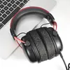 A pair of black and red headphones rests on a laptop keyboard. Anteprima dell’immagine prodotto