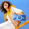 A woman is laughing and holding up a transparent phone case with a blue background. Produktbild-Vorschau