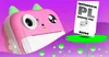 A pink cartoon-like camera with green ears sits on a purple wavy surface, next to a manual with Polish text. Anteprima dell’immagine prodotto