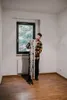 A man is holding skis in an empty room with a window. Anteprima dell’immagine prodotto