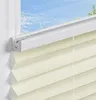 A close-up view of a cream-colored pleated blind installed on a window frame, with a blue sky visible through the window. Produktbild-Vorschau