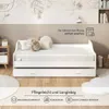 A white daybed with a mattress and pillows, set in a room with a decorative wall mural and wooden flooring. Produktbild-Vorschau