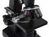 A close-up view of the stage and objective lenses of a microscope. Produktbild-Vorschau