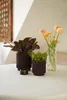 A still life arrangement of plants and flowers on a table. Voir les images du produit