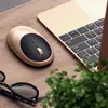 A gold and black computer mouse is placed on a wooden desk next to a laptop and a pair of glasses. Produktbild-Vorschau