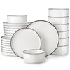 A collection of white ceramic plates and bowls with thin black rims, neatly stacked and arranged. Voir les images du produit
