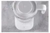 A top-down view of a white electric kettle on a gray textured surface. Náhled obrázku produktu