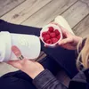 A person holding a shaker bottle and a small container of raspberries. Voir les images du produit