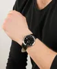 A person wearing a black shirt and a watch on their wrist. Voir les images du produit