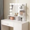 A white vanity table with a lighted mirror and various makeup items. Náhled obrázku produktu
