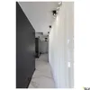 A modern hallway with a dark wall, marble floor, and sheer white curtains. Produktbild-Vorschau