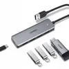 A Ugreen USB hub and several USB flash drives are arranged on a white background. Produktbild-Vorschau