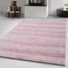 A pink rug with a textured pattern is laid out on a light gray floor, with a stack of logs and a fireplace in the background. Voir les images du produit
