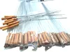 A pile of BBQ skewers with wooden handles, some are loose and some are packaged in plastic. Produktbild-Vorschau