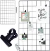 A black metal grid display board with several photos and cards attached using clips, shown alongside a large black clip and a smaller grid. Anteprima dell’immagine prodotto