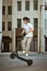 A person riding an electric scooter in an urban environment. Produktbild-Vorschau