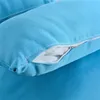 A close-up view of a light blue cushion with a partially unzipped opening, revealing the white filling. Produktbild-Vorschau