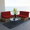 Outdoor balcony with a view of the ocean, featuring pallet furniture with red cushions and a coffee table. Voir les images du produit