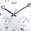 Close-up of a white analog clock face with a thermometer and hygrometer. Voir les images du produit