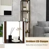 A modern living room scene featuring a tall shelf unit with integrated LED lighting, showcasing decorative items on its shelves. A close-up inset shows a detail of the shelf with a diffuser and cup. Náhľad obrázku produktu