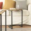 Two small side tables are placed in front of a white sofa with several decorative pillows. Voir les images du produit