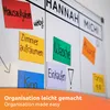 A whiteboard with colorful sticky notes indicating tasks and names. Anteprima dell’immagine prodotto
