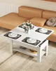 A white coffee table with place settings and a vase of flowers is shown in a living room setting next to a tan sofa. Voir les images du produit