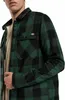 Close-up of a man wearing a green and black plaid shirt. Podgląd zdjęcia produktu