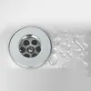 A close-up view of a sink drain with water droplets on the surrounding surface. Produktbild-Vorschau