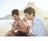 A couple sharing earphones on a beach. Anteprima dell’immagine prodotto