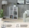 A white bookshelf with books and decorative items in a modern living room setting. Produktbild-Vorschau