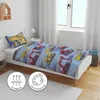 A child's bed with bedding featuring construction vehicles, next to a window and a shelf. Produktbild-Vorschau