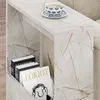 A side table with books and a cup of tea on it, placed next to a sofa. Produktbild-Vorschau