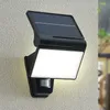 A solar-powered outdoor wall light with a motion sensor is mounted on a textured wall. Produktbild-Vorschau
