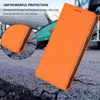 An orange phone case is shown in a close-up, with a background of cracked asphalt and industrial machinery. Náhled obrázku produktu
