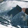 A hand is using a snow brush to clear snow from a car windshield. Voir les images du produit