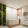 A modern bathroom with a freestanding bathtub, a vertical garden wall, and a vanity with a round mirror. Produktbild-Vorschau