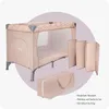 A beige travel crib with a leopard print trim, along with its folded mattress and carrying bag, is displayed against a soft purple and beige background. Náhled obrázku produktu