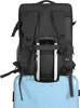A black backpack is placed on top of a light blue suitcase. Produktbild-Vorschau