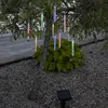 Solar-powered LED icicle lights hanging from a tree branch in a garden setting. Produktbild-Vorschau