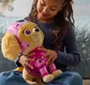 A young girl is holding a plush toy dog. Podgląd zdjęcia produktu