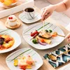 A table setting with a meal being served, including plates, cutlery, a cup of tea, and food. Náhled obrázku produktu