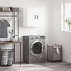 A laundry room scene with a washing machine, laundry basket, and a wall-mounted cabinet. Podgląd zdjęcia produktu