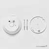 A white smoke detector and its mounting hardware are laid out on a white background. Voir les images du produit