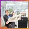 A man sits in an airport lounge reading a newspaper next to a black suitcase. Anteprima dell’immagine prodotto